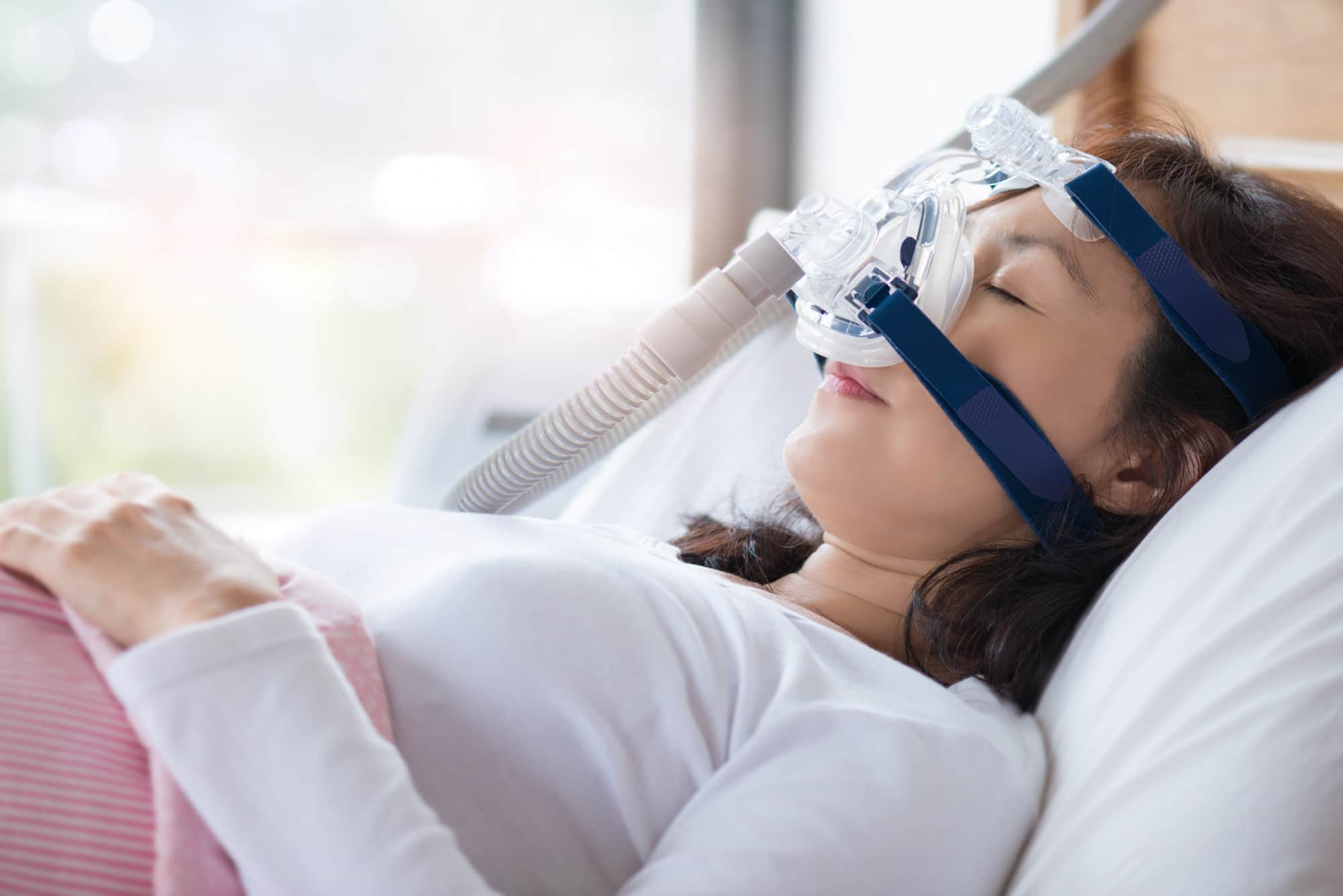 Restful lady wearing a CPAP equipment