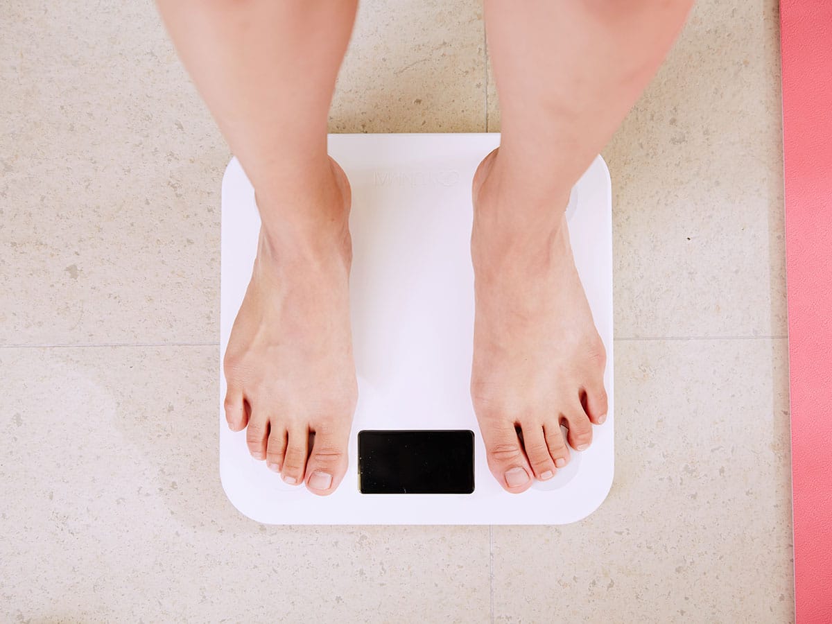 체중 증가에 대해 걱정하는 흰색 디지털 욕실 규모의 사람