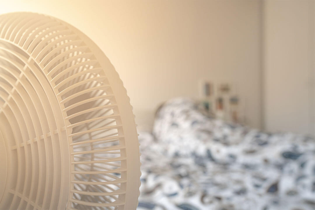 Electric fan running next to bed