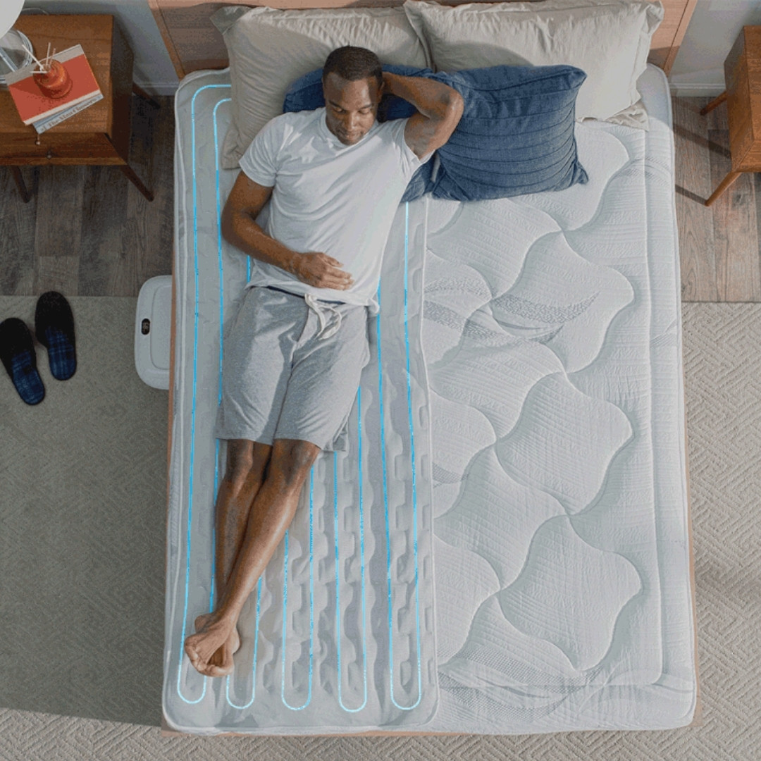 Man stretches out on top of his Chilisleep Cooling Mattress Pad