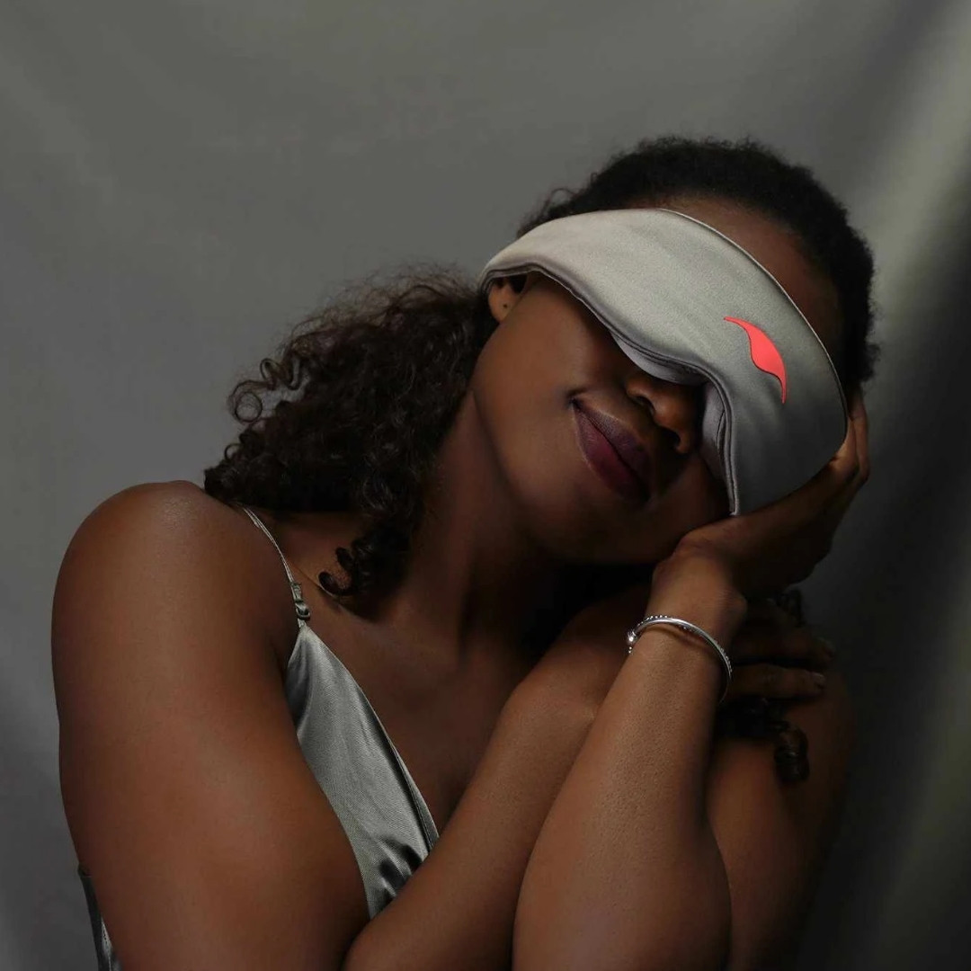 Young woman slips on her Manta blackout sleep mask