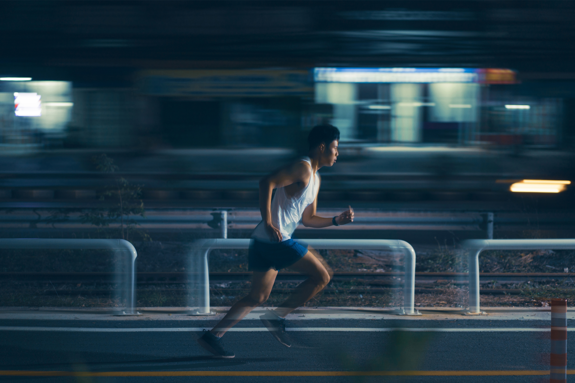A young man running in the city at night.