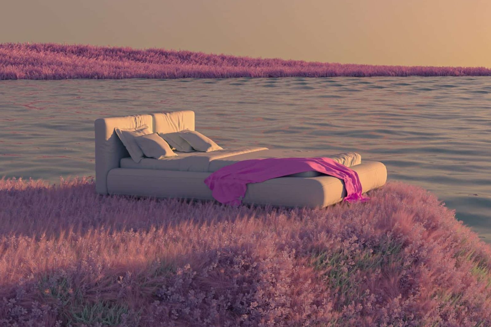 A bed ready for sleep sits in a meadow above the bay