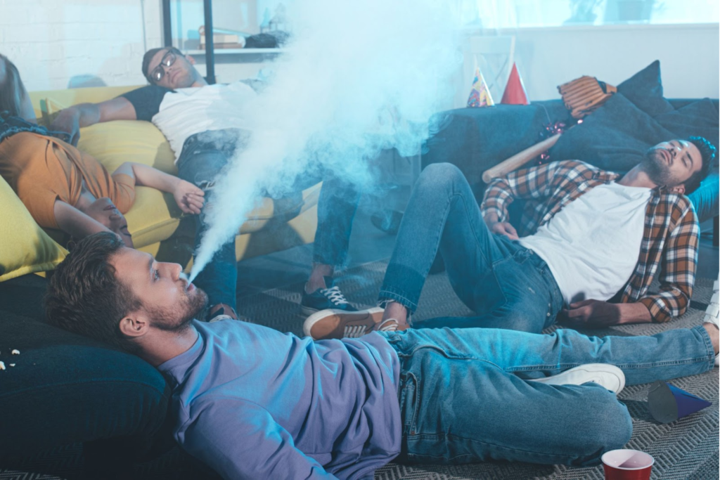 A group of men vaping at a party.