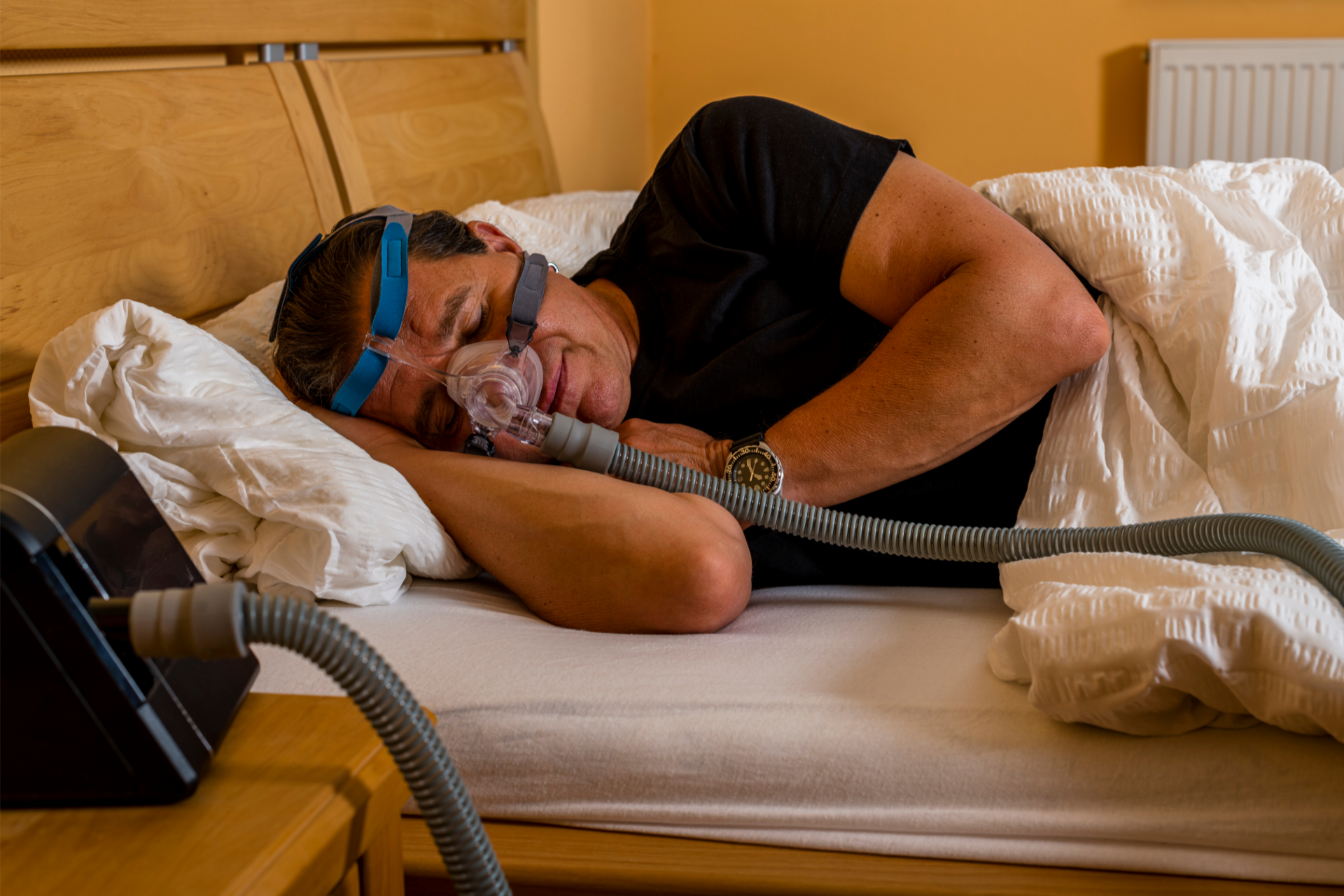 A man with sleep apnea sleeping in a CPAP mask.