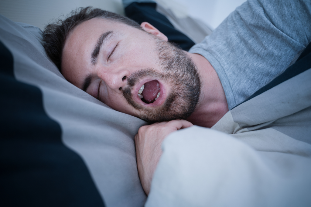 A man snores loudly while trying to fall asleep.