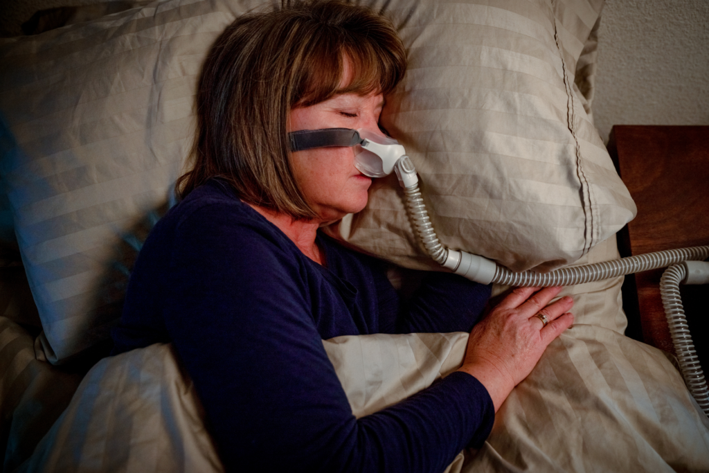 A women treats her sleep apnea with CPAP.